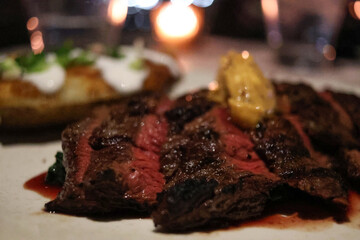 High quality close up photo of sliced fresh, juicy and delicious grilled rare beef tenderloin steak  with creamy sauce, mustard butter , mashed potato, pepper and salt.