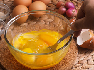 OLYMPUhand mix the eggs in glass bowl with a fork,  ingredient as a background eggs, red onion,...