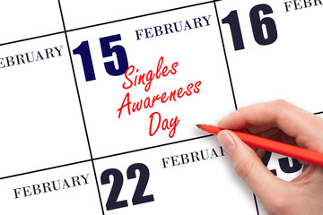 February 15. Hand writing text Singles Awareness Day on calendar date. Save the date.