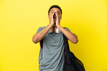 Young sport African American man with sport bag isolated on yellow background shouting and announcing something
