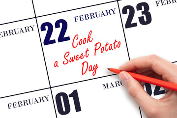 February 22. Hand writing text Cook a Sweet Potato Day on calendar date. Save the date.
