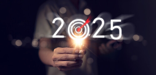 Businessman holding light bulb on black background, concept of setting goals for 2025