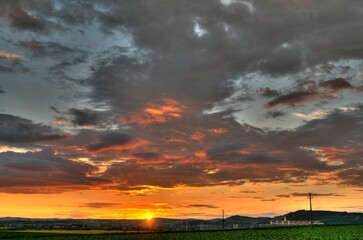 The golden sun sinks below the horizon, casting a warm glow over the vast, bountiful field of crops.