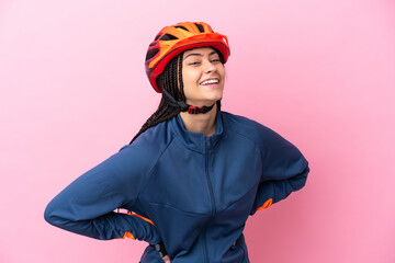 Teenager cyclist girl isolated on pink background posing with arms at hip and smiling - obrazy, fototapety, plakaty