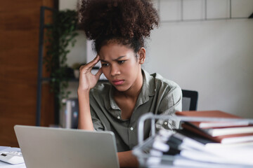 African american businesswoman headache and stressful while reading finance business data on laptop