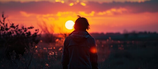 Obraz premium A person observing the setting sun.