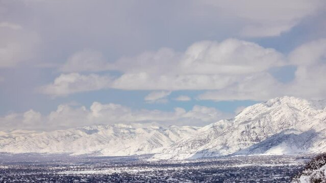 Time lapse of the suburbs of Salt Lake City and snow covered Wasatch Mountains.