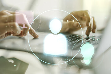 Double exposure of social network icons concept with hands typing on laptop on background....
