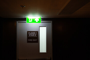 Fire exit neon lighting that installed on ceiling in front of fire escape doorway at the end of...
