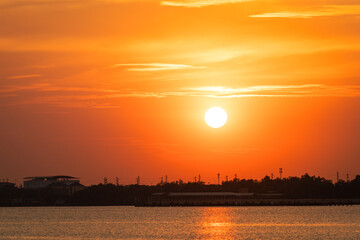 Beautiful view of the orange sunlight during sunset time in the golden hour with river on foreground. Nature view scene.