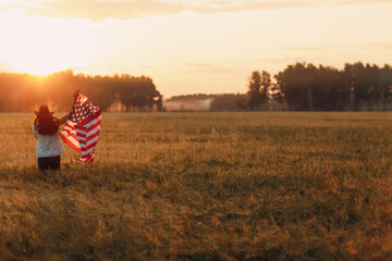 Patriotic Independence day 4th of July Woman farmer in the agricultural field with american flag on sunset.