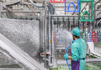 Worker disinfecting interior of a butchery.