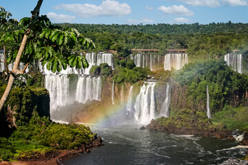 Water cascading over the Iguacu falls with rainbow in Brazil
