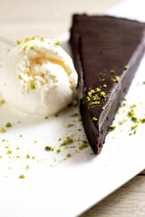 Chocolate cake brownie with ice cream and pistachio on white background