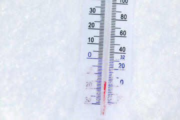 Outdoor thermometer in snow shows frigid winter temperature