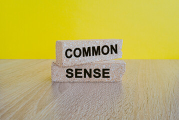 Common sense symbol. Concept words Common sense on beautiful brick blocks. Beautiful yellow background. Business, motivational common sense concept. Copy space.