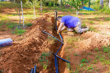 Plumber uses thermal insulation PE foam to cover underground PVC water pipes