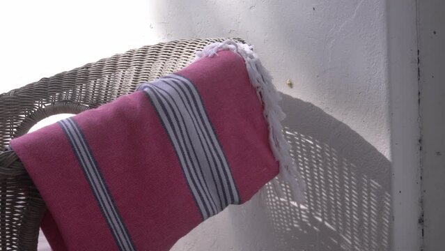 Close up of pink blanket blowing on back of chair