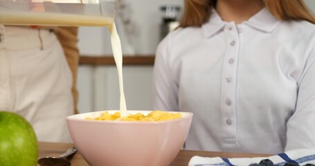 Milk elegantly flows into cereal bowl cinematic slow-motion family breakfast Healthy tasty start...