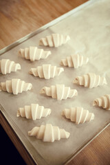 Top view shot, lay out sweet or savory pastries, croissant dough pieces on baking tray covered with parchment. Concept of nature, food, diet, cooking, nutrition, bakery, recipes.