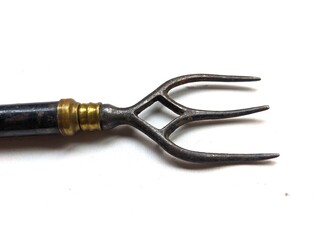 Close up of enamelled metal toasting fork