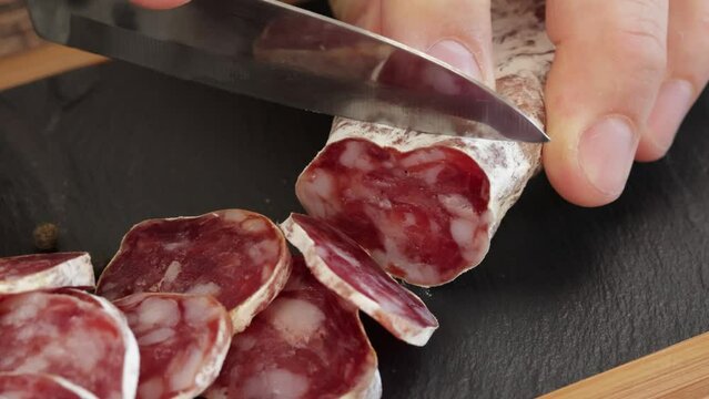 d&eacute;coupe d'un saucisson sec, en gros plan