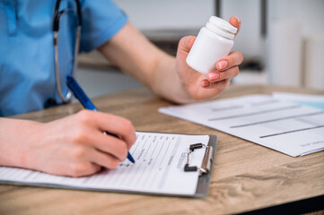 Selective focus on bottle with medication prescribing to sick patient