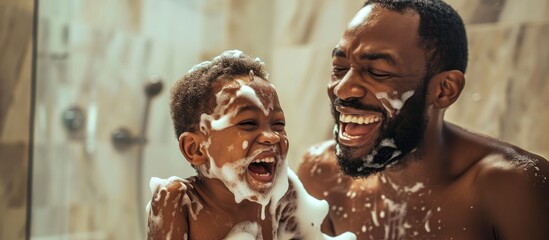 Happy African father and son enjoying playful moment with shaving foam in bathroom. - obrazy, fototapety, plakaty