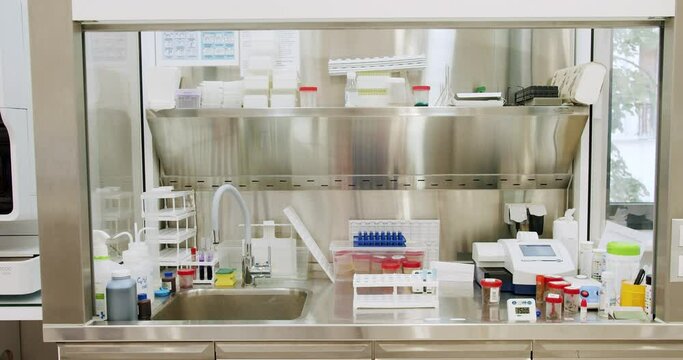Workspace in medical laboratory, sink with water tap, blood samples, urine tests, feces containers, reagents and different equipment for researching and examination. Biochemistry analysis concept