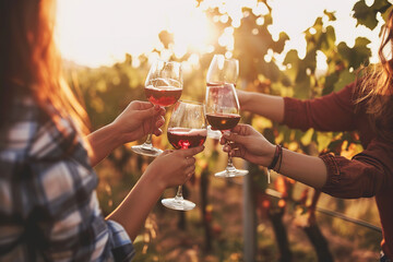 Blurred image of friends toasting wine in a vineyard in the daytime outdoors. Happy friends having fun outdoors - obrazy, fototapety, plakaty
