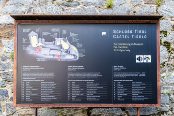 Dorf Tirol, South Tyrol, northern Italy, June 14, 2023: Information sign pointing to the historic medieval Tyrol Castle. - obrazy, fototapety, plakaty