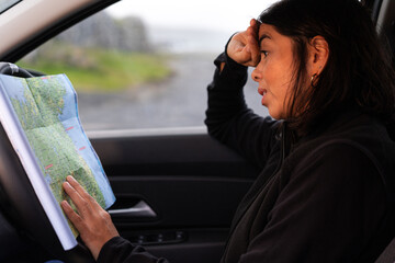Woman inside the vehicle checking the map and mobile phone to prepare her next route destination by car in Ireland