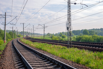 Railway against a beautiful colorful sky at sunset. Industrial landscape with railroad, blue sky with clouds in summer. Railway junction in the evening.