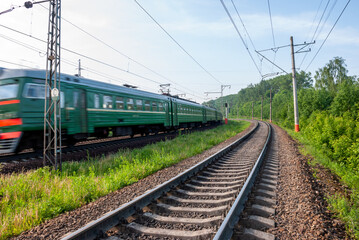 Obraz premium Railway against a beautiful colorful sky at sunset. Industrial landscape with railroad, blue sky with clouds in summer. Railway junction in the evening.