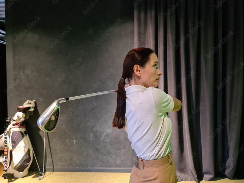 Wall mural girl playing golf on screen and golf simulator concept