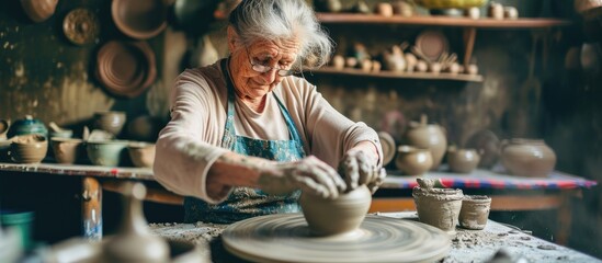 Happy elderly white woman sculptor creating clay pot on pottery wheel, representing small business, entrepreneurship, home hobby, entertainment, leisure in art studio. - Powered by Adobe