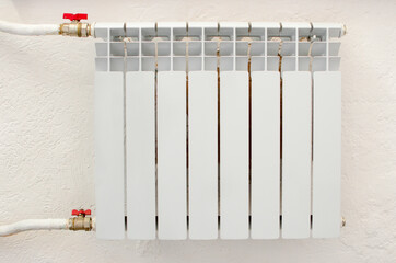 A white heating heater hangs on the wall.