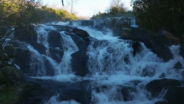 Castriz Waterfall Waters Flowing Down To The River In Summer In Santa Comba, Galicia, Spain. - wide shot