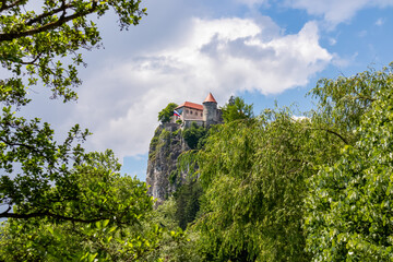 Panoramic view medieval castle at Lake Bled, Upper Carniola, Slovenia. Serene landscape in remote nature of the Julian Alps in summer. Tourist attraction. Oldest Slovenian castle surrounded by forest