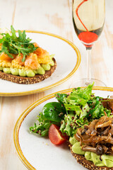 Two open sandwiches with mushrooms and salted salmon  with sparkling wine. Food background.