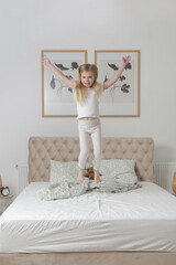 Adorable little girl jummping on the bed