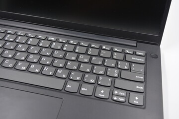 A beautiful stylish black 14 inch laptop with a simplified, miniature, slim keyboard with no calculator keys.