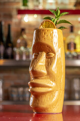 Refreshing cold Tiki cocktail on the bar. Summer party background.