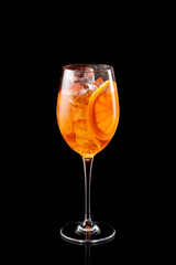 Glass of Aperol Spritz cocktail isolated on a black background.