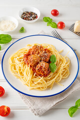 Traditional Italian spaghetti pasta with meatballs, tomato sauce and parmesan cheese, selective focus. Comfort food.