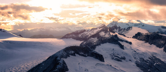 Glacier and Rocky Mountains covered in snow and clouds. Canadian Aerial Nature Landscape