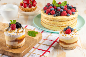 Sweet desserts with fresh berries on wooden background.