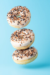 Creative layout of fresh donuts on blue background. Minimal food concept.