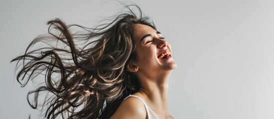 A white background sets the stage as a young woman with long hair laughs and waves it.