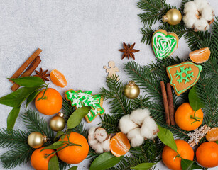 Winter, New Year, Christmas composition of Christmas tree branches, gingerbread, tangerines, decor, spices on a light background. Horizontal, free copy space.